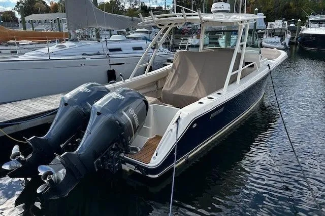 Slide: The Image of 2014 Pursuit ST 310 Sport boat docked with twin outboard engines. - 4