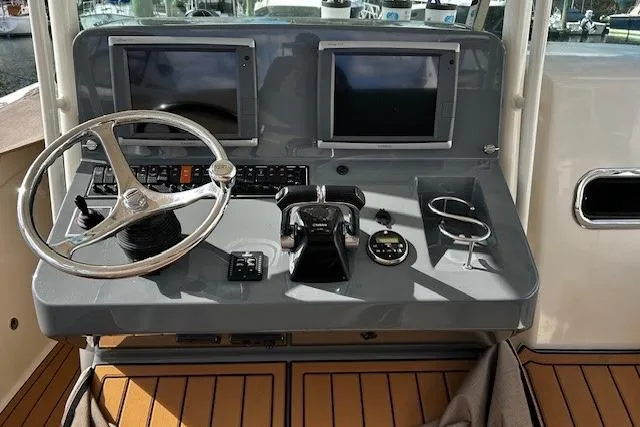 Slide: The Image of Helm of 2014 Pursuit ST 310 Sport boat with dual screens and steering wheel. - 9