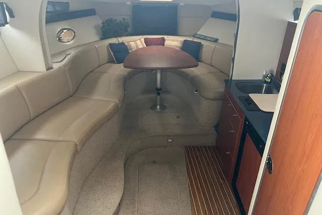 Slide: The Image of Interior of 2006 Bayliner 325 boat with seating, table, and kitchenette. - 10