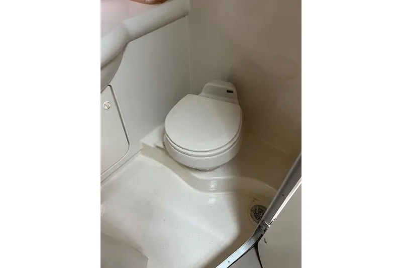 Slide: The Image of 2006 Bayliner 325 boat bathroom with compact white toilet. - 17