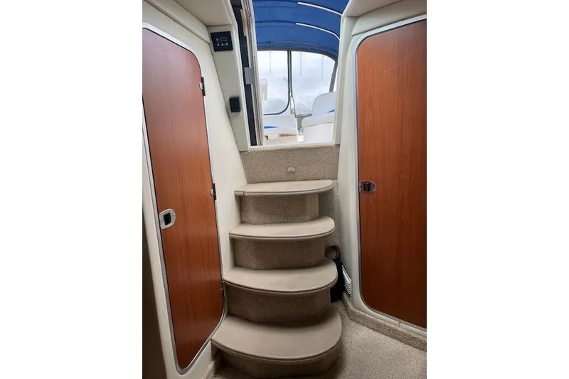 Slide: The Image of Interior view of 2006 Bayliner 325 yacht with carpeted stairs and wooden doors. - 18