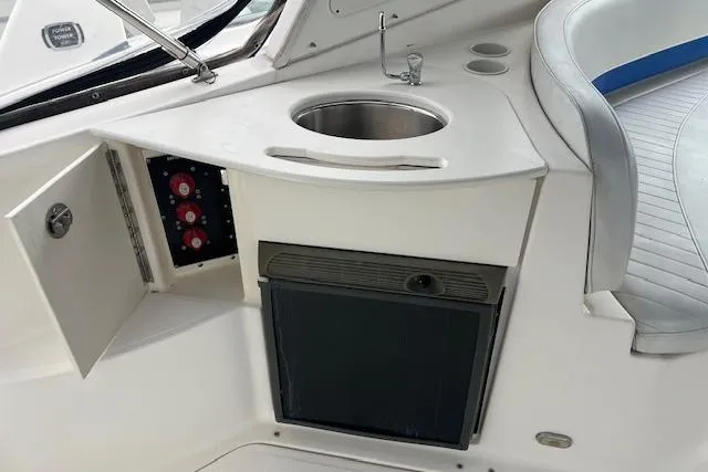 Slide: The Image of 2006 Bayliner 325 boat interior with sink, control panel, and seating area. - 3