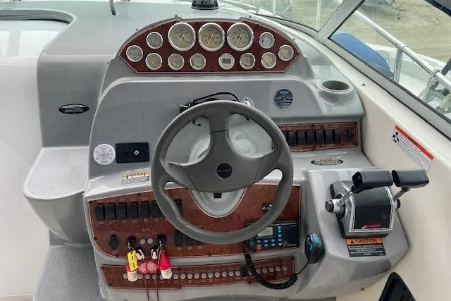 Slide: The Image of 2006 Bayliner 325 boat dashboard with steering wheel and control panel. - 7
