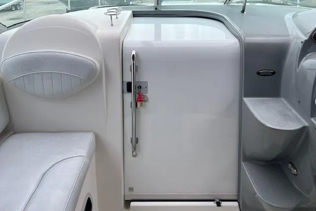 Slide: The Image of Interior view of a 2006 Bayliner 325 boat, featuring seating and a cabin door. - 8