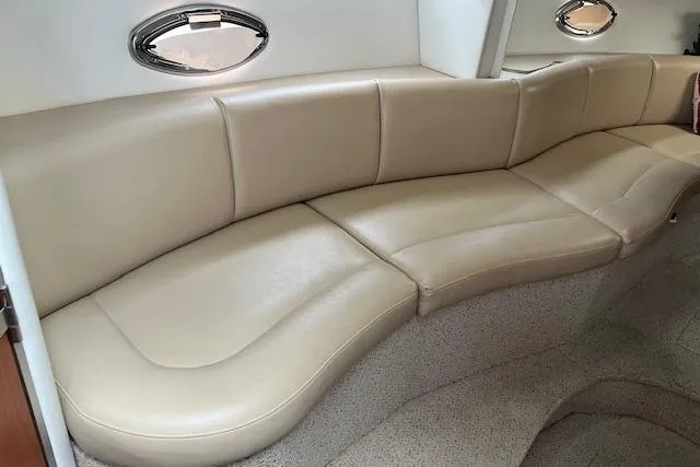 Slide: The Image of 2006 Bayliner 325 interior with beige leather seating and oval windows. - 9