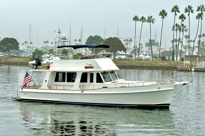 Slide: The Image of 2009 Grand Banks 47 Heritage EU yacht cruising near palm-lined marina. - 2