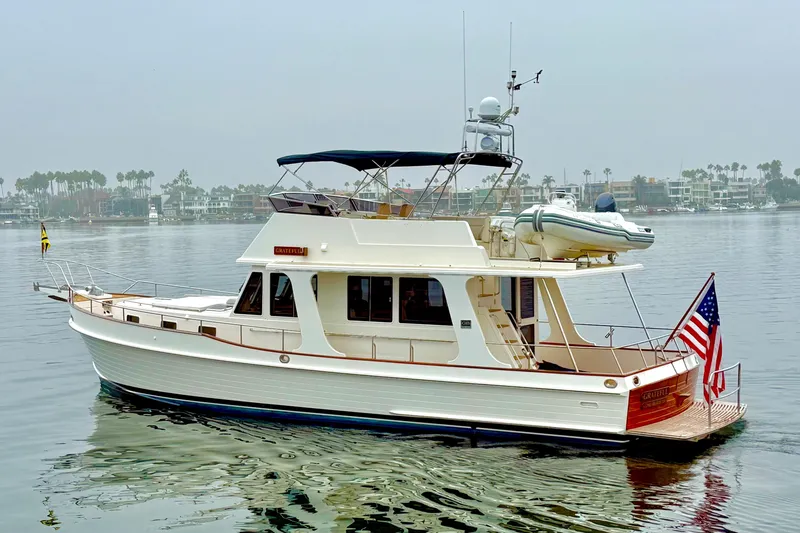 Slide: The Image of 2009 Grand Banks 47 Heritage EU yacht on calm water, featuring classic design and American flag. - 3