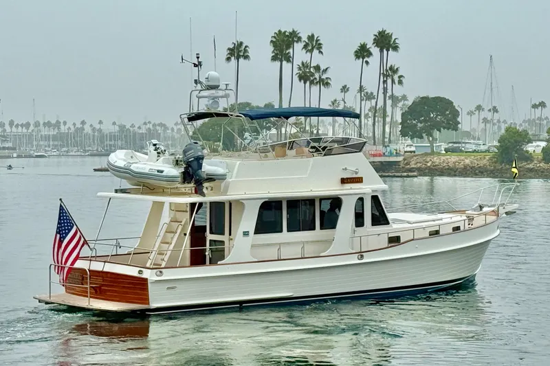 Slide: The Image of 2009 Grand Banks 47 Heritage EU yacht cruising near palm-lined marina. - 4