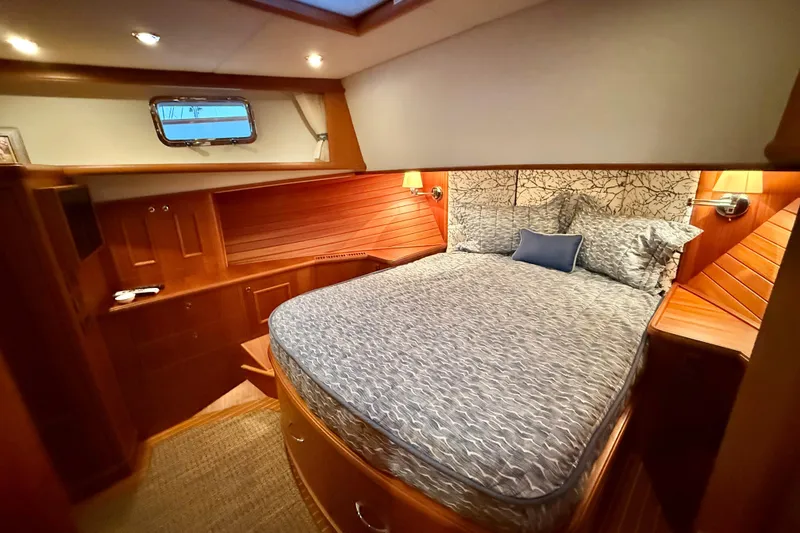 Slide: The Image of Luxurious cabin interior of 2009 Grand Banks 47 Heritage EU yacht, featuring elegant woodwork and cozy bedding. - 53