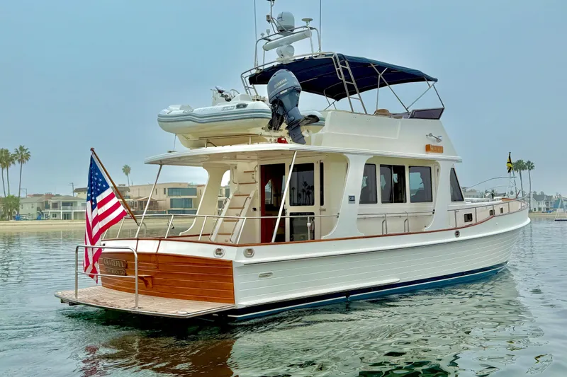 Slide: The Image of 2009 Grand Banks 47 Heritage EU yacht on calm water, displaying an American flag. - 6