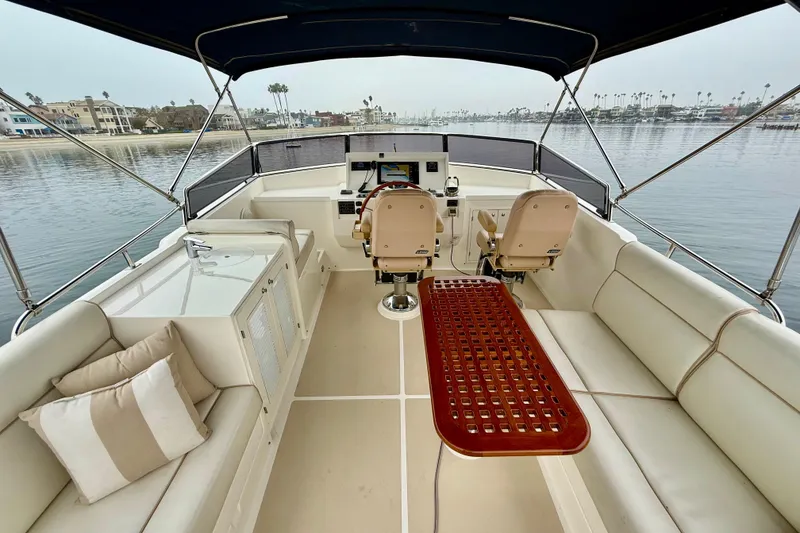 Slide: The Image of Flybridge of 2009 Grand Banks 47 Heritage EU yacht with seating and helm, overlooking calm waters. - 65