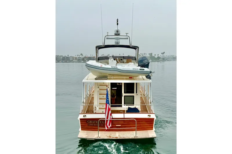 Slide: The Image of 2009 Grand Banks 47 Heritage EU yacht on calm water, rear view with American flag. - 8