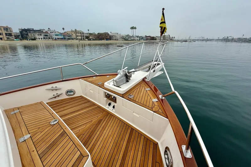 Slide: The Image of 2009 Grand Banks 47 Heritage EU yacht with teak deck, anchored near coastal homes. - 82