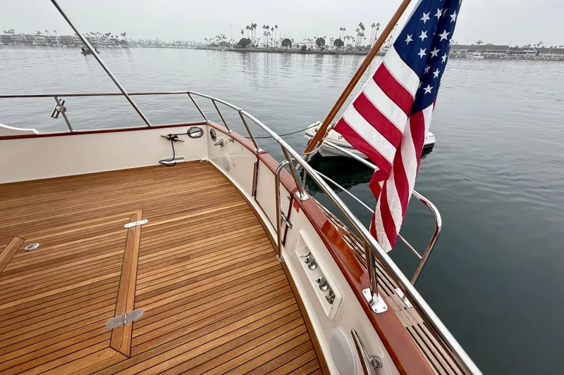 Slide: The Image of 2009 Grand Banks 47 Heritage EU yacht deck with American flag, overlooking calm waters. - 85