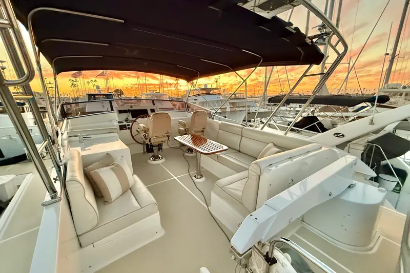 Slide: The Image of 2009 Grand Banks 47 Heritage EU yacht interior with sunset view, featuring elegant seating and helm. - 95