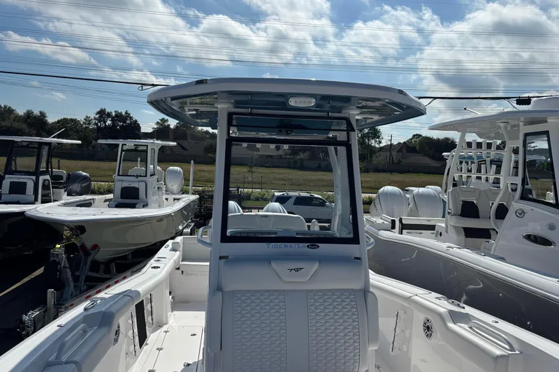 Slide: The Image of 2026 Tidewater 272 LXF boat with sleek design and spacious deck under a cloudy sky. - 13