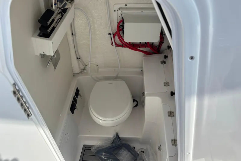 Slide: The Image of 2026 Tidewater 272 LXF boat interior with compact marine toilet and storage. - 15