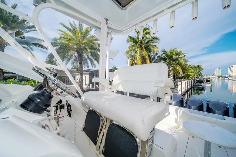 Slide: The Image of 2011 SeaVee 430 Sport Express boat interior with white seating, palm trees, and marina view. - 18