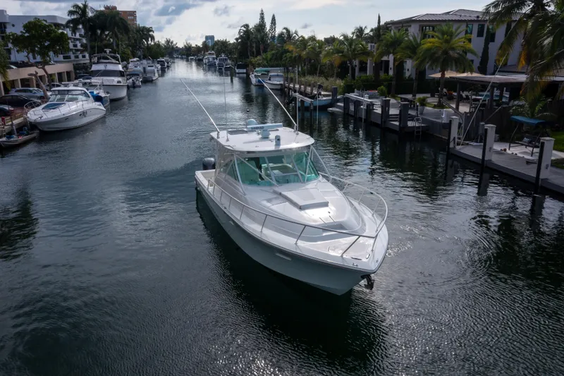 Slide: The Image of 2011 SeaVee 430 Sport Express yacht cruising in a scenic canal with palm trees. - 6