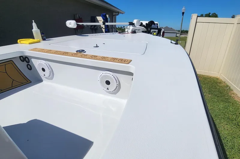 Slide: The Image of 2022 East Cape Vantage VHP boat deck with speakers and equipment, parked outdoors. - 12