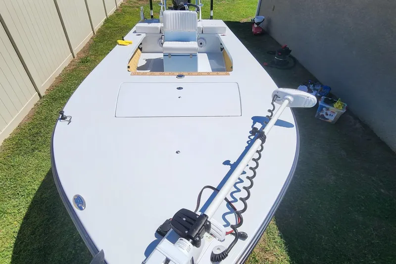 Slide: The Image of 2022 East Cape Vantage VHP boat with trolling motor, parked on grass beside a fence. - 8