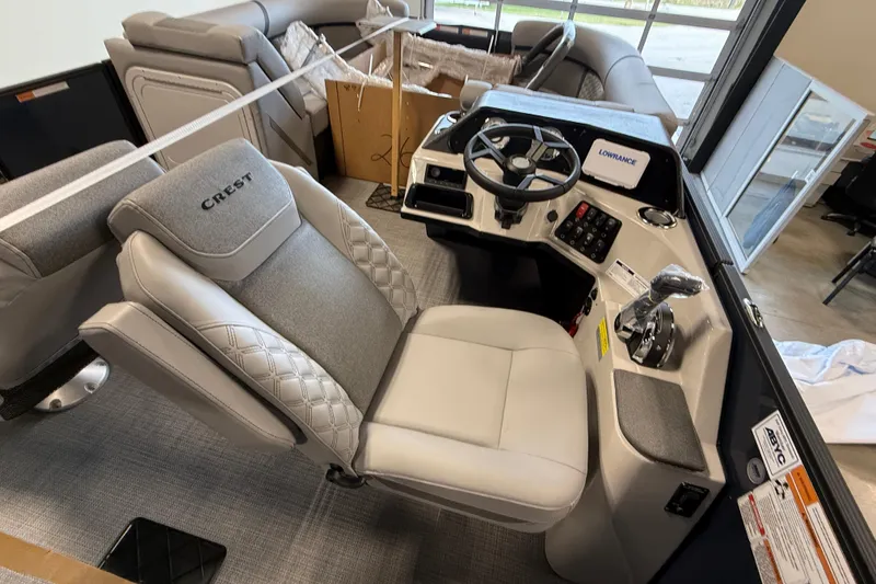 Slide: The Image of 2026 Crest Conquest 230 SLSC boat interior with steering console and seating. - 11