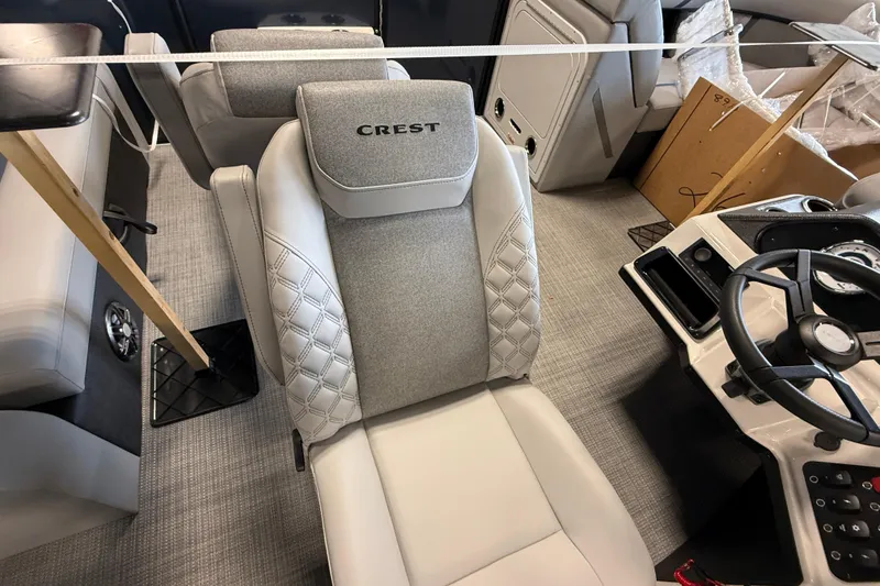 Slide: The Image of 2026 Crest Conquest 230 SLSC boat interior with luxurious seating and modern steering console. - 12
