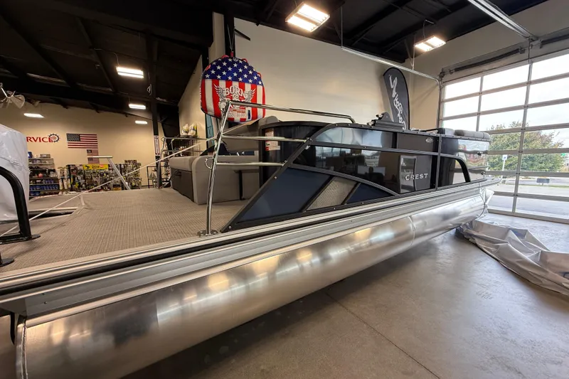 Slide: The Image of 2026 Crest Conquest 230 SLSC pontoon boat displayed indoors, showcasing sleek design and modern features. - 3