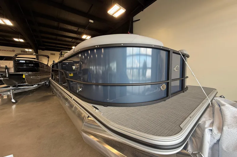 Slide: The Image of 2026 Crest Conquest 230 SLSC pontoon boat displayed indoors, showcasing sleek design. - 4