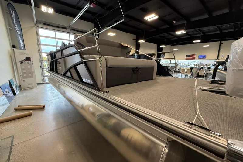 Slide: The Image of 2026 Crest Conquest 230 SLSC pontoon boat displayed in a showroom setting. - 7