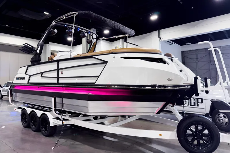 The Image of 2026 Montara Surf Boss EVO SL 23' boat on display indoors, featuring sleek design and vibrant lighting. - 1