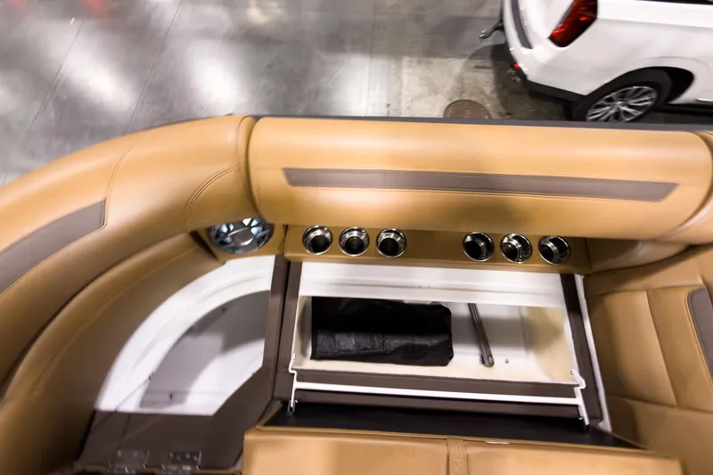 Slide: The Image of Interior of 2026 Montara Surf Boss EVO SL 23' boat with tan leather seating and storage compartment. - 11