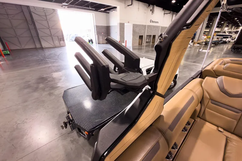 Slide: The Image of 2026 Montara Surf Boss EVO SL 23' boat interior with tan seating and wakeboard rack. - 27