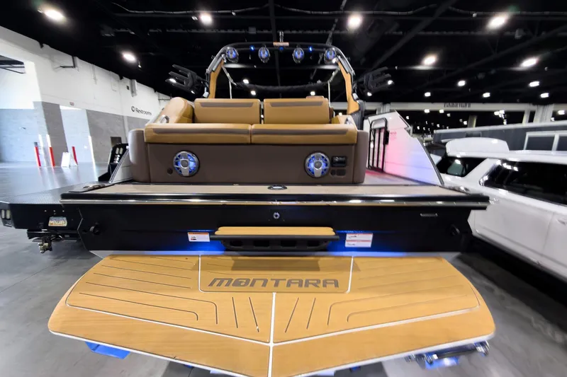 Slide: The Image of 2026 Montara Surf Boss EVO SL 23' boat displayed indoors, showcasing rear seating and deck. - 4