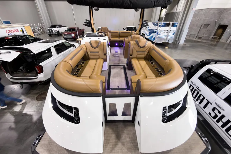 Slide: The Image of 2026 Montara Surf Boss EVO SL 23' boat with luxurious seating at an indoor exhibition. - 7