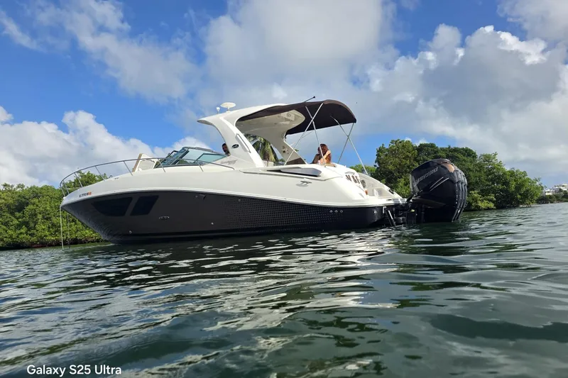 Slide: The Image of 2010 Sea Ray 370 Sundancer boat on water, under a clear blue sky. - 13