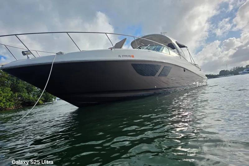 Slide: The Image of 2010 Sea Ray 370 Sundancer yacht on calm water under cloudy sky. - 3