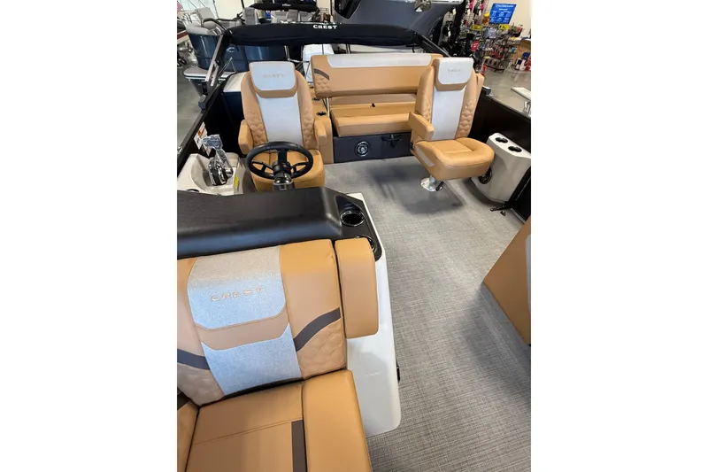 Slide: The Image of 2026 Crest Conquest 230 SLSC boat interior with tan and gray seating, steering wheel, and cup holders. - 13