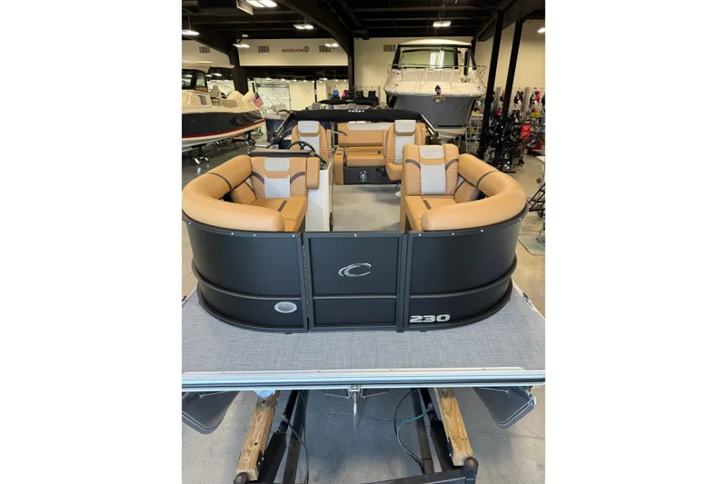 Slide: The Image of 2026 Crest Conquest 230 SLSC pontoon boat with tan seating in showroom. - 3