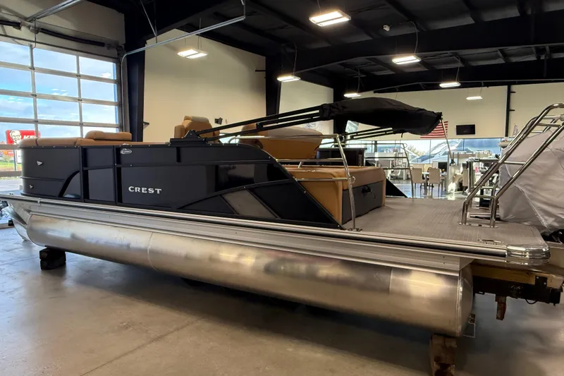 Slide: The Image of 2026 Crest Conquest 230 SLSC pontoon boat displayed in a showroom. - 5