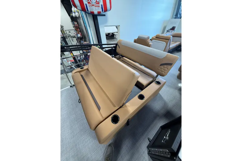 Slide: The Image of 2026 Crest Conquest 230 SLSC boat seating with cup holders, displayed in showroom. - 7