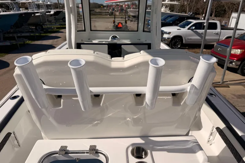 Slide: The Image of 2026 Tidewater 2700 Carolina Bay boat with rod holders and seating, parked outdoors. - 24