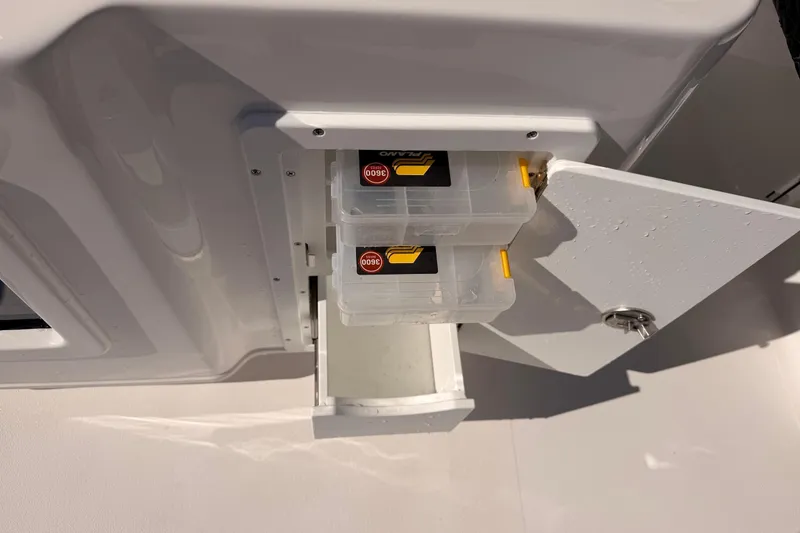 Slide: The Image of Tidewater 2700 Carolina Bay 2026 boat storage compartment with tackle boxes. - 27