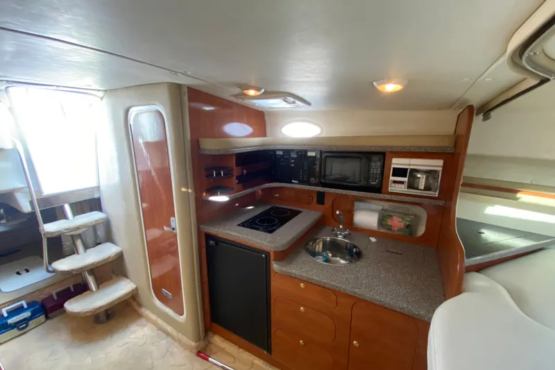 Slide: The Image of 2004 Rinker Fiesta Vee 342 interior kitchen with stove, sink, and microwave. - 14