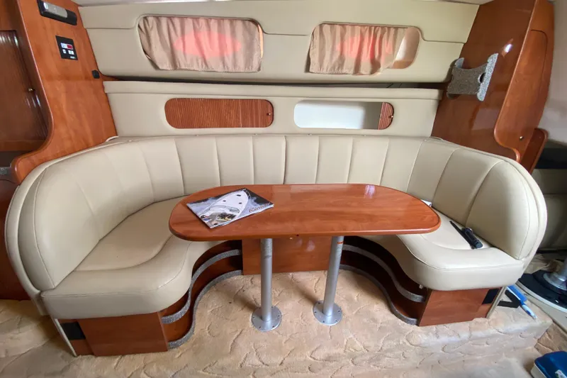 Slide: The Image of 2004 Rinker Fiesta Vee 342 interior with beige seating and wooden table. - 15