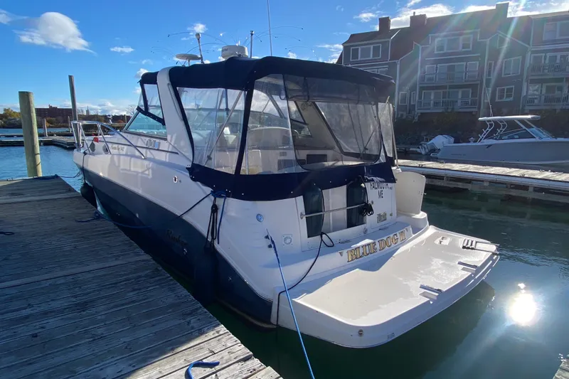 Slide: The Image of 2004 Rinker Fiesta Vee 342 docked at marina, clear day, waterfront buildings in background. - 3