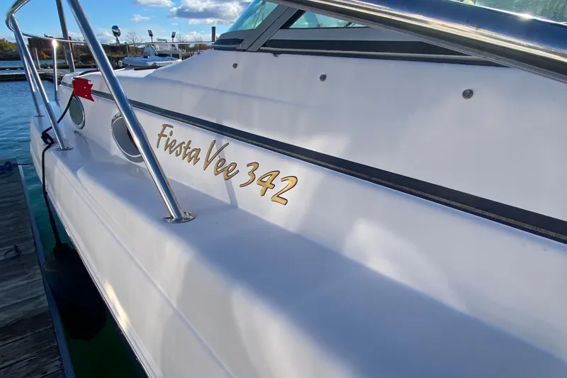 Slide: The Image of 2004 Rinker Fiesta Vee 342 boat docked, showcasing sleek design and branding. - 4