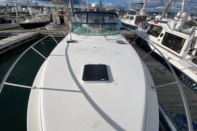 Slide: The Image of 2004 Rinker Fiesta Vee 342 docked at marina, view of bow and surrounding boats. - 6