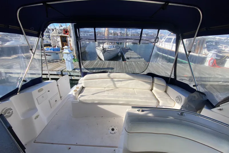 Slide: The Image of 2004 Rinker Fiesta Vee 342 boat interior with white seating at marina. - 9