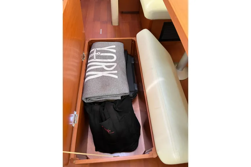 Slide: The Image of Storage compartment on 2020 Beneteau Oceanis 46.1 yacht with folded blanket and bag. - 48
